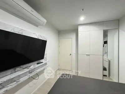 Modern bedroom with sleek TV setup and stylish wardrobe