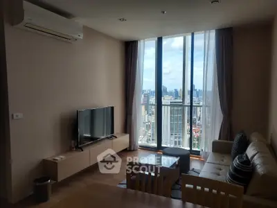 Modern living room with city view, featuring sleek furniture and large windows for natural light.