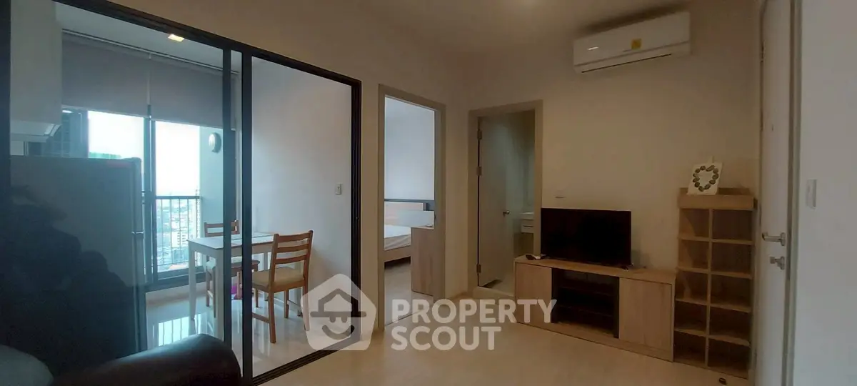 Modern apartment interior with open living room and dining area, featuring air conditioning and natural light.