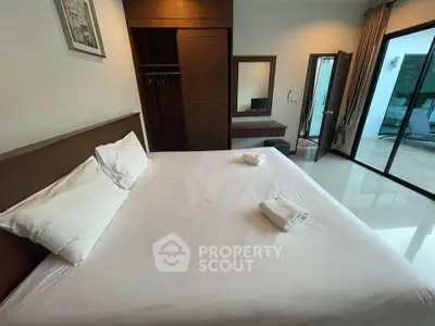 Spacious bedroom with modern furnishings and access to a private balcony, ideal for relaxation.