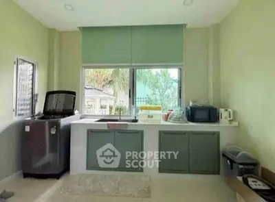 Bright kitchen with modern appliances and large windows offering garden view