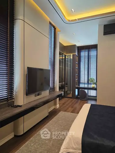 Luxurious modern bedroom with sleek design and ambient lighting, featuring a large TV and stylish decor.