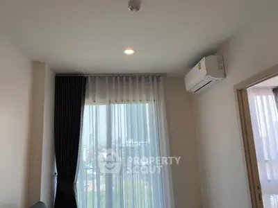 Modern apartment interior with large window and air conditioning unit, offering a bright and airy atmosphere.