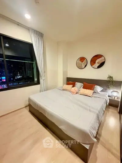 Modern bedroom with large window and stylish decor in urban apartment