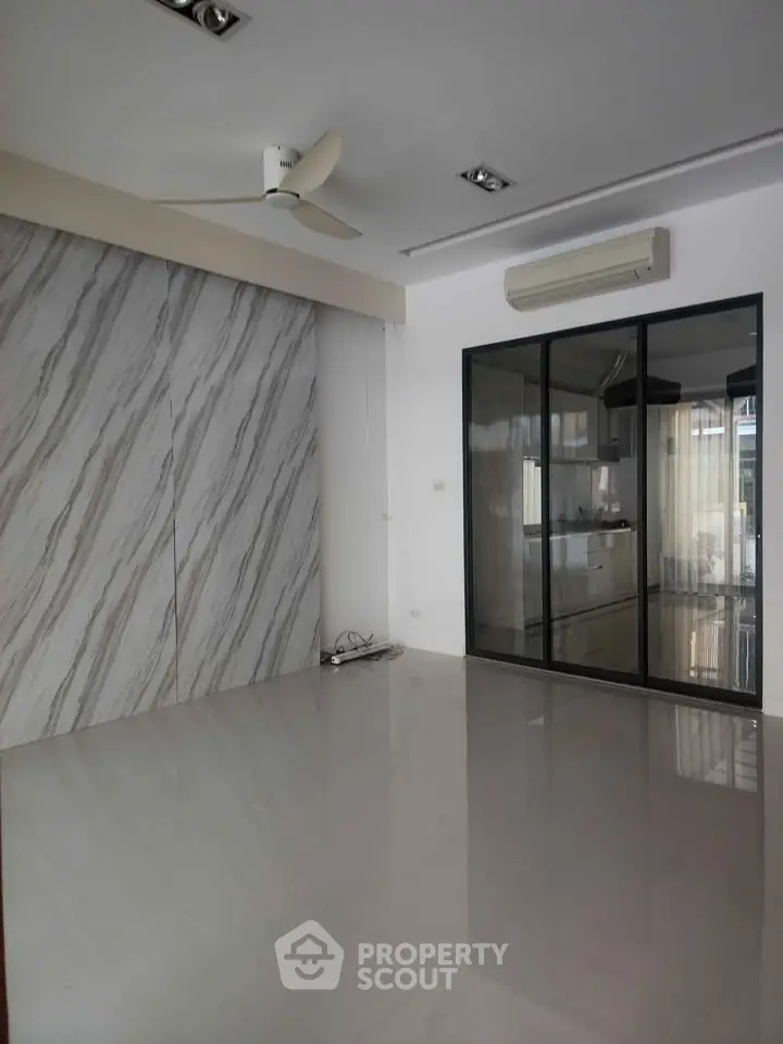 Modern living room with marble accent wall and glass partition