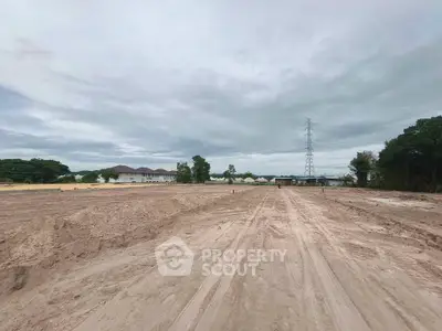Expansive land plot ready for development with clear skies and surrounding greenery.