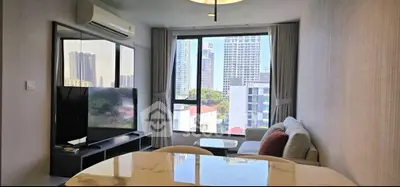 Modern living room with city view, featuring sleek furniture and large windows for natural light.