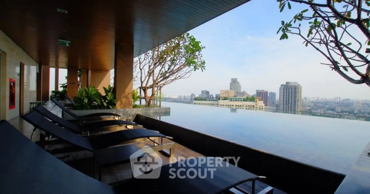 Luxurious rooftop infinity pool with stunning city skyline view and modern lounge chairs.