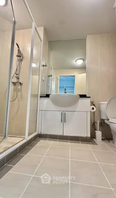 Modern bathroom with sleek fixtures and spacious shower in contemporary apartment.