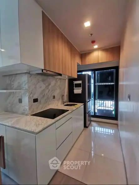 Modern kitchen with sleek cabinetry and marble countertops in a stylish apartment.