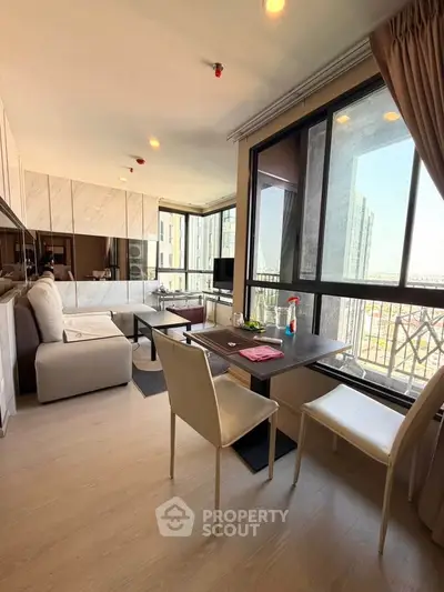 Modern living room with large windows and stylish furniture in a high-rise apartment.