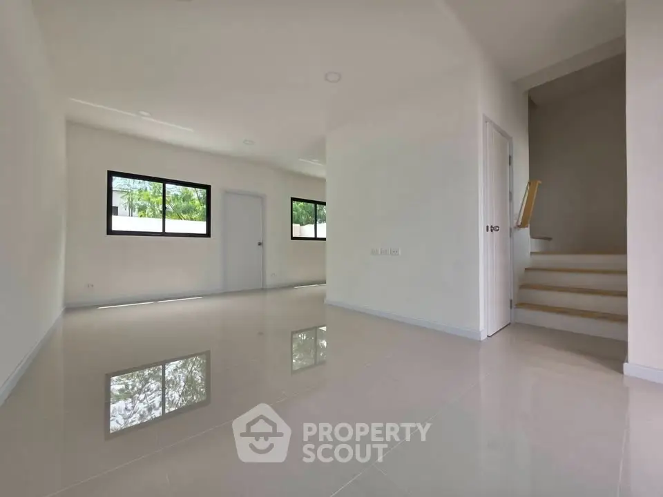 Spacious modern living room with glossy tile flooring and natural light.