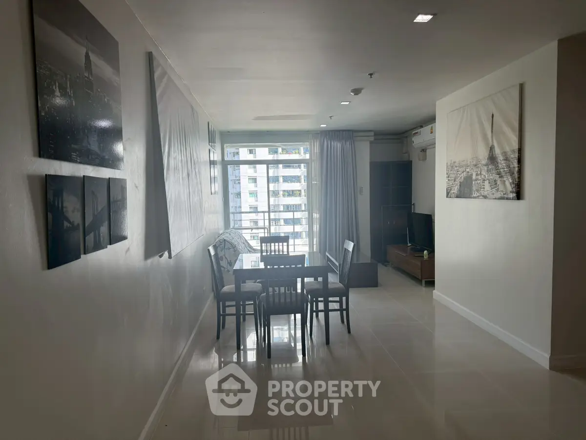 Modern dining area with city view and stylish wall art in a high-rise apartment.