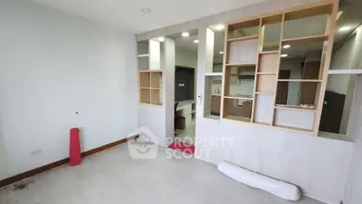 Modern open-layout living space with stylish partition and kitchen view