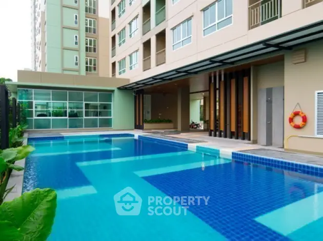 Luxurious apartment complex with a pristine swimming pool and modern architecture.