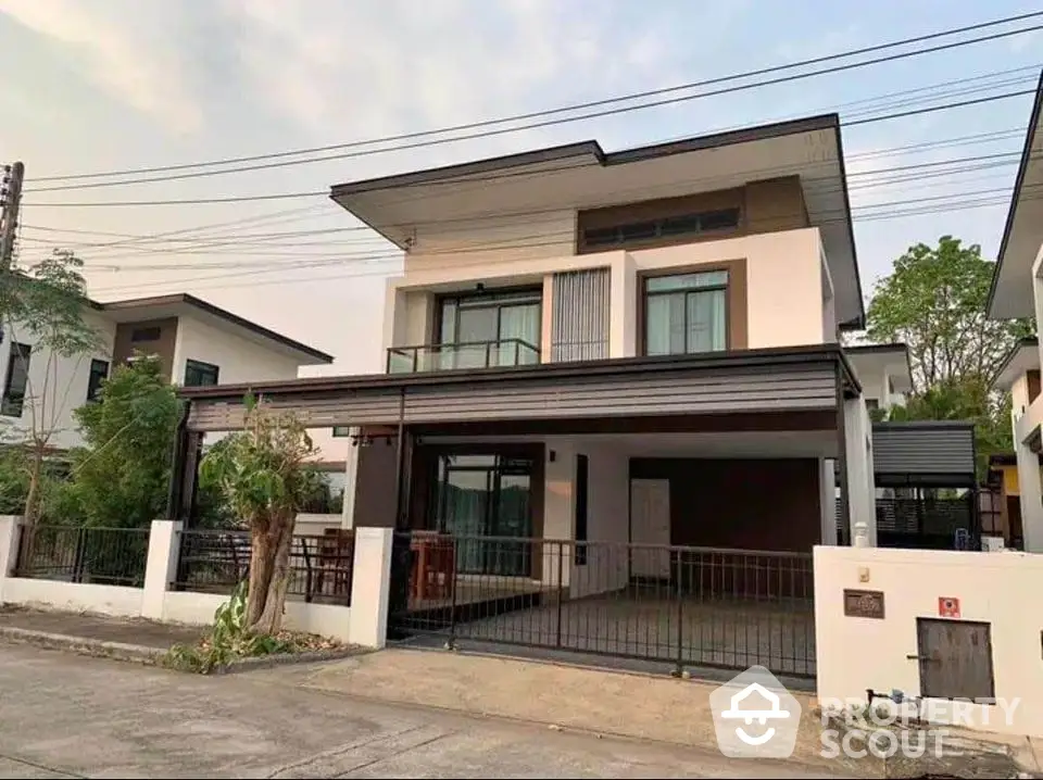 Modern two-story house with spacious driveway and sleek architectural design in a suburban neighborhood.