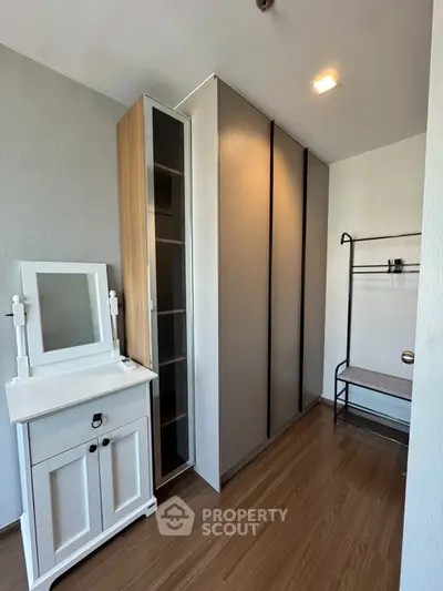 Modern bedroom with sleek wardrobe and stylish vanity in a cozy apartment.