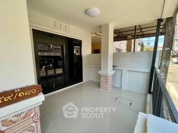 Charming balcony with tiled flooring and street view, perfect for relaxation.