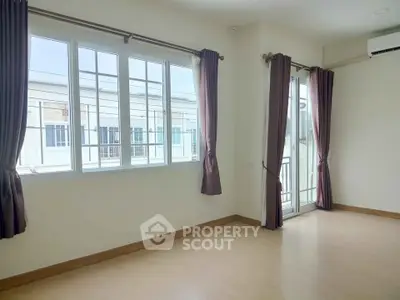 Spacious empty room with large windows and balcony access, perfect for customization.
