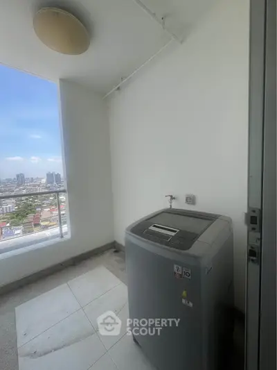 High-rise apartment balcony with washing machine and city view