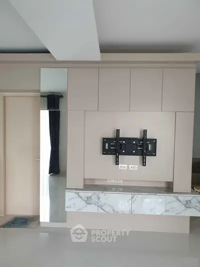 Modern living room with sleek TV mount and marble accents, perfect for stylish home entertainment setup.