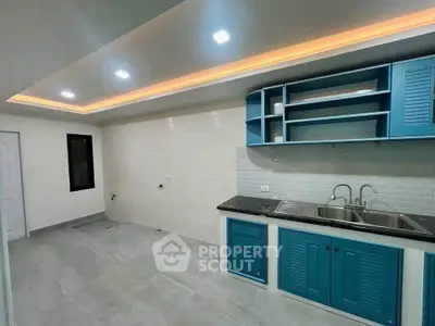 Modern kitchen with blue cabinets and sleek lighting, perfect for culinary enthusiasts.