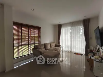 Spacious living room with large windows and modern furniture