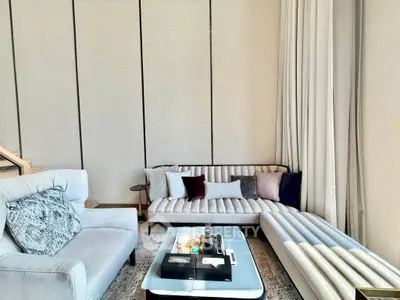 Luxurious modern living room with elegant furniture and high ceilings, perfect for sophisticated urban living.