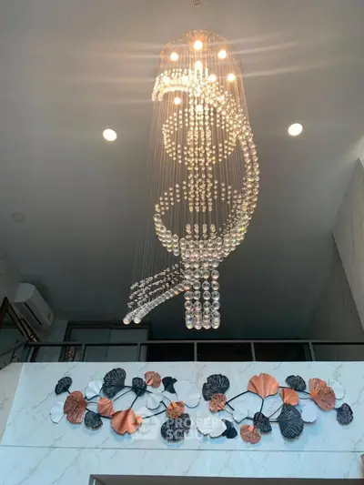 Luxurious chandelier in modern living room with elegant wall decor