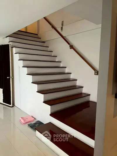 Elegant wooden staircase with sleek design and polished finish in modern home interior.