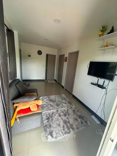 Cozy living room with modern decor and wall-mounted TV in a compact apartment.