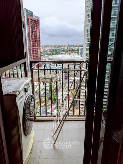 High-rise balcony with washing machine and city view, perfect for urban living.