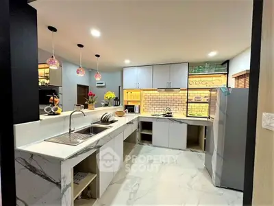 Modern kitchen with marble countertops and stylish lighting