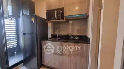 Modern compact kitchen with sleek appliances and balcony access