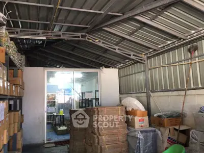Spacious storage area with metal roof and organized shelving, ideal for warehouse or industrial use.