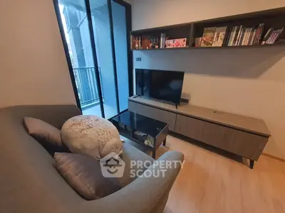Cozy living room with modern TV setup and balcony view