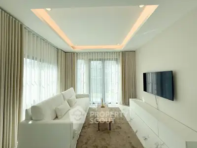 Elegant modern living room with white sofa, sleek TV setup, and ambient lighting.