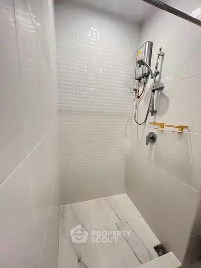 Modern bathroom with sleek white tiles and shower unit