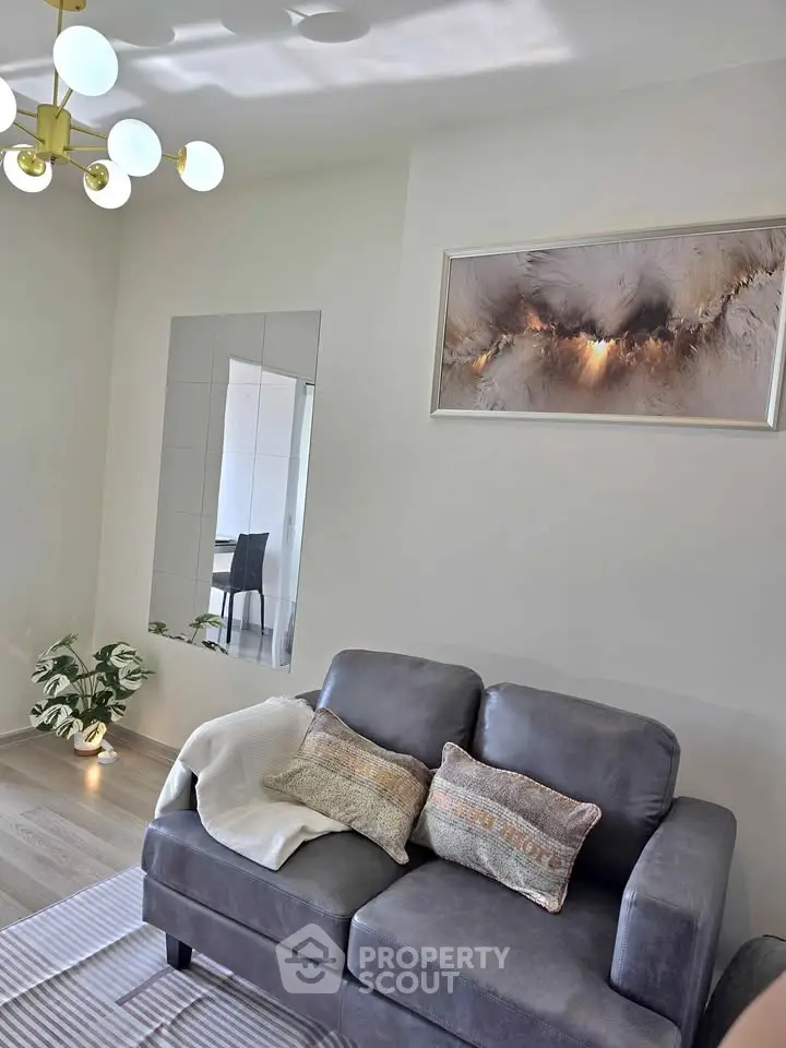 Modern living room with stylish decor and cozy seating area, featuring elegant lighting and contemporary artwork.
