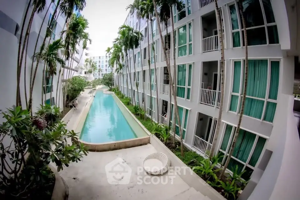 Modern apartment complex with pool and lush greenery, offering a serene living environment.