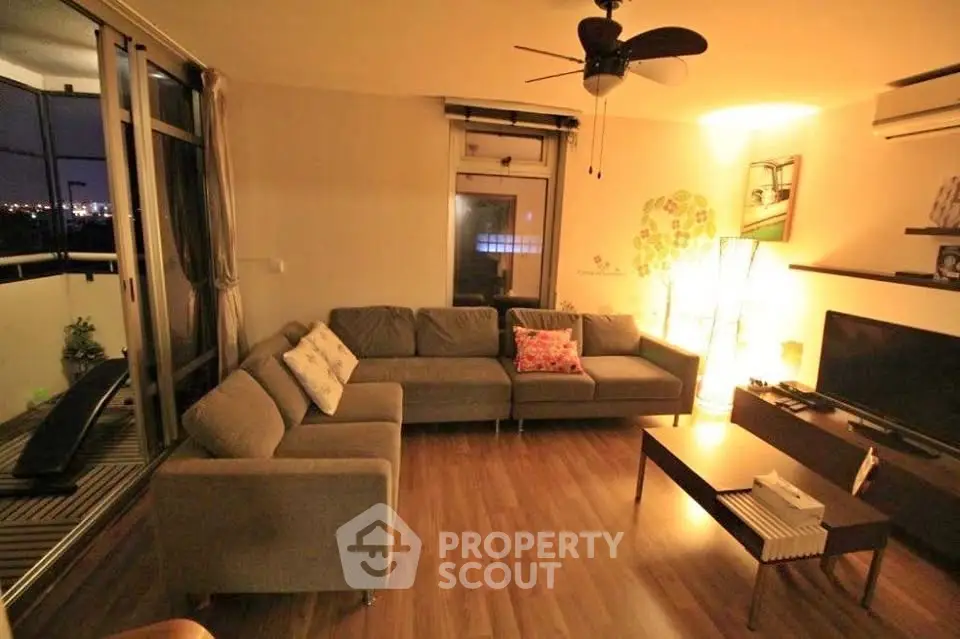 Spacious living room with modern decor and large windows offering city views.