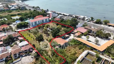 Aerial view of a prime waterfront property with development potential, featuring lush greenery and proximity to amenities.
