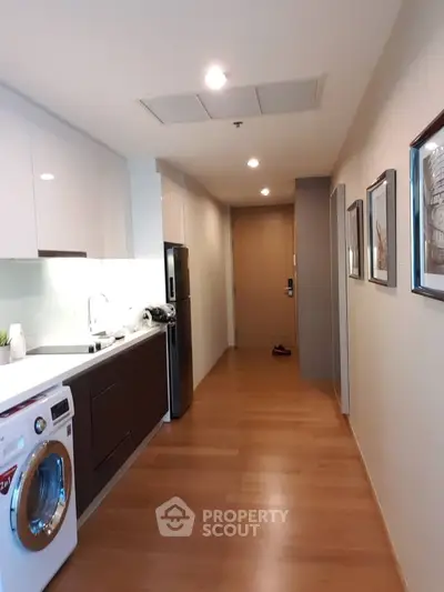 Modern apartment hallway with sleek kitchen and washing machine