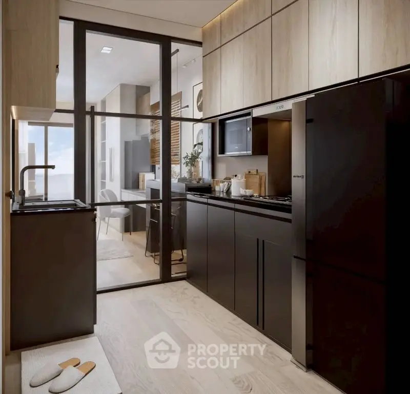 Modern kitchen with sleek black cabinets and glass door leading to dining area.