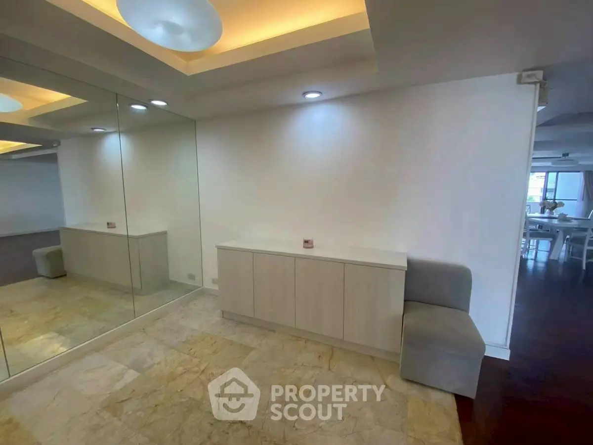 Spacious modern interior with elegant lighting and mirrored wall, perfect for stylish living.