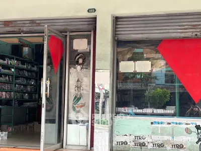 Charming storefront with glass door and large display windows, ideal for retail or small business.