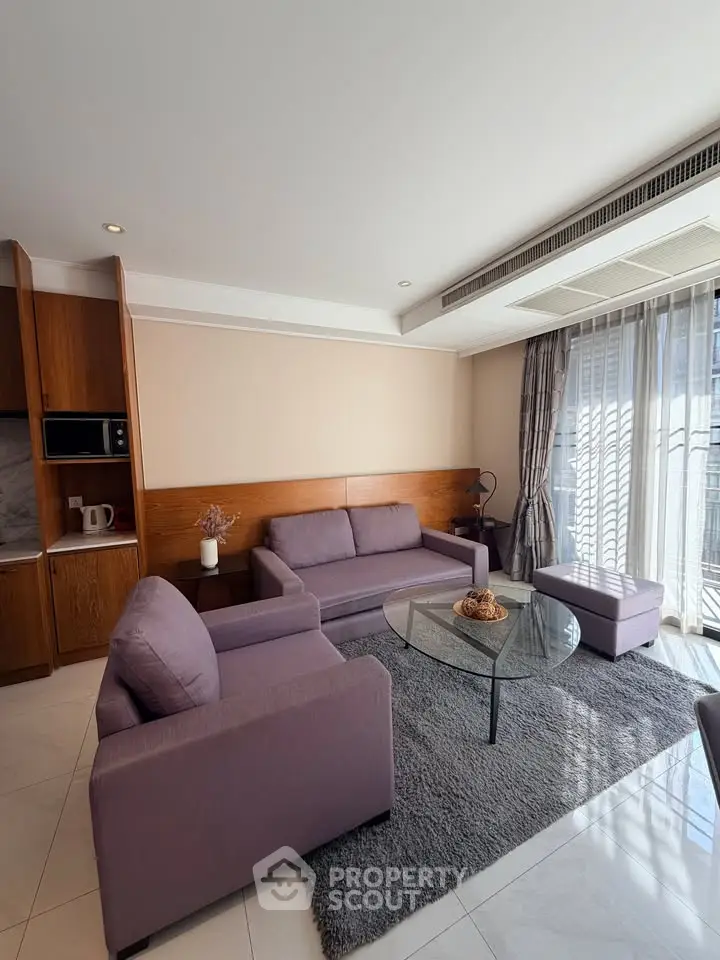 Modern living room with stylish furniture and natural light, featuring a cozy seating area and elegant decor.