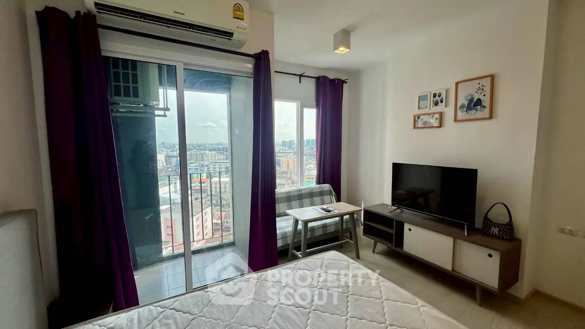Modern bedroom with balcony and city view, featuring a TV and stylish decor.
