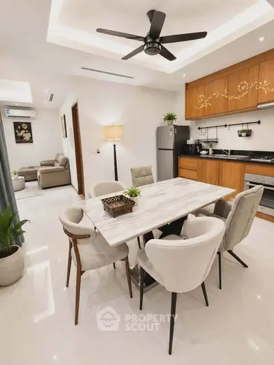 Elegant dining area with marble table, modern kitchen, and cozy living room in open layout apartment.