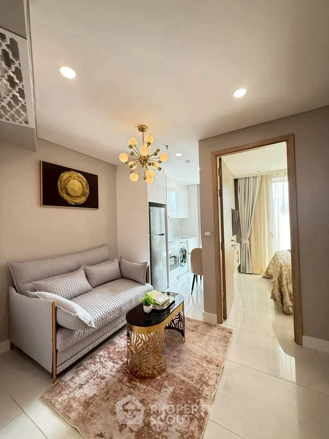 Modern living room with elegant decor and open view to bedroom and kitchen